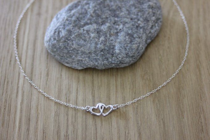 Collier ras de cou en argent massif de style minimaliste avec pendentif coeur entrelacés, le tout en