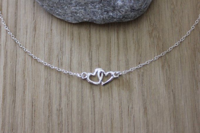 Collier ras de cou en argent massif de style minimaliste avec pendentif coeur entrelacés, le tout en